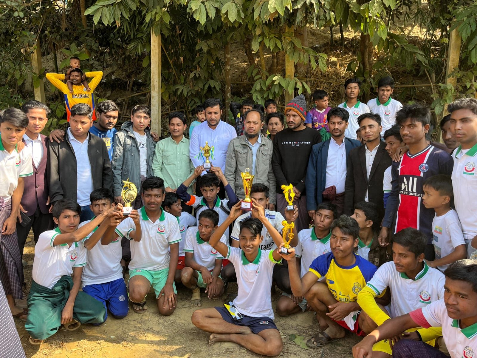 Large group of students and staff holding up the day's trophies together